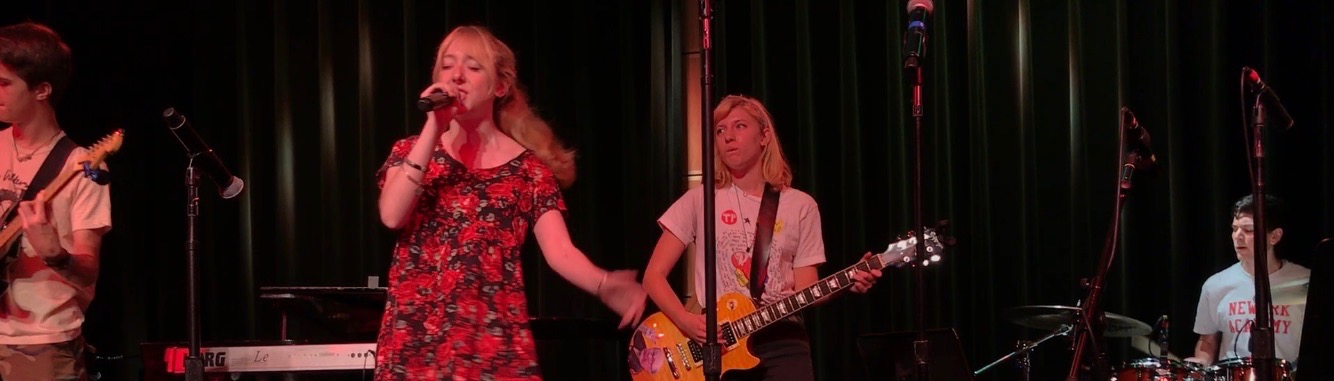 Wren, onstage, in a red dress